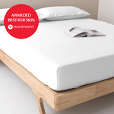 White smooth-finish 100% organic bamboo flat bed sheet with snug fit and clean edges on cotton mattress