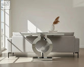 Modern silver console table with a chrome finish and o-shaped base perfect as a sleek silver console for entryways
