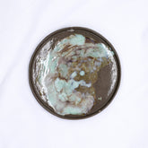 A 27 cm pure white smoked grey round stoneware plate with a dark brown rim and teal beige purple glaze from ribera handmade ceramics