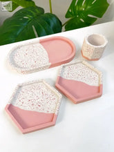 Set of modern pink split terrazzo-style trays and matching cylindrical cup in speckled white concrete for trinkets