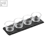 Set of four clear ribbed glass bowls arranged on a black slate tray perfect for serving shots or snacks