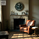A vintage 40cm wall clock with a black face white numerals and dark metallic frame with brass fittings requiring 1 aa battery