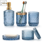 Set of five blue textured glass bathroom accessories with gold accents including soap dish and cotton swab jars