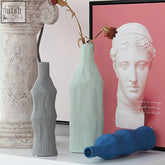 A set of two fresh ceramic vases featuring a sleek ribbed design in soft mint green with slender necks and flared bases