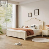 Cream-colored upholstered agnes king size bed with curved headboard and panelled footboard with storage