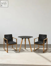 Modern outdoor dining set with round black tabletop, wooden legs, and light wood chairs with woven seats perfect for outdoor dining