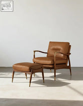 Brown leather aizawa lounge chair with wooden legs and gold metal accents made from real leather