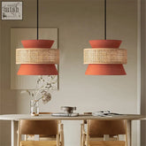 Two terracotta aka light pendant lights with woven rattan bands hang above a dining table