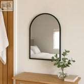 Black metal arched wall mirror akiko 70x50cm with minimalist frame above wooden console table