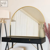 Akiko gold arched metal mirror with gold frame resting on black vanity with gold hardware 95cm by 120cm
