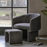 Modern gray velvet akko dining armchair with matching ottoman featuring sleek curved lines and minimalist design