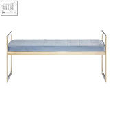 Light blue tufted cushion on an allure powder blue and gold tufted bench with polished metal legs and rails