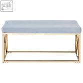 A sleek allure bench with powder blue velvet seat and gold-toned metal frame featuring an x-shaped cross design