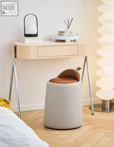 A modern alpha dressing table stool with a soft gray fabric body and warm brown pu leather seat