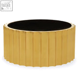Gold-colored fluted cylindrical round coffee table with black circular top from alvaro black and titanium collection