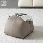 Beige leather amara large foot stool with stitched seams and metal ring handle for comfy foot rest