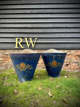 Two vintage blue metal garden bins with gold lettering and decorative insignia used as grape hod log baskets