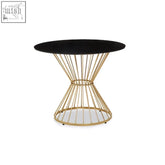 Black glass dining table with a round tabletop and gold hourglass wireframe base perfect for modern dining spaces