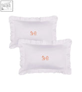 White pillowcase pair with delicate ruffle frill edges and subtle peach arabella bow ruffle embroidery