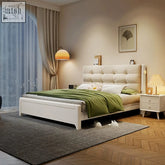 Cream-colored tufted arlene wood king size storage bed with white bedding and green throw blanket