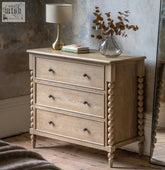 Light oak wood artisan 3 drawer chest with turned bead legs and dark metal knobs for stylish storage