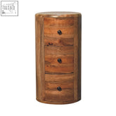 A rustic drum chest made of solid mango wood with four drawers and dark round knobs in an oak-ish finish