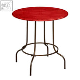 Artisan red metal circular table with a decorated textured top and slender metal legs