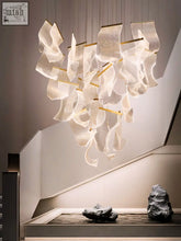 A modern atsushi light chandelier with flowing white translucent fabric and gold-toned metal rods hanging elegantly