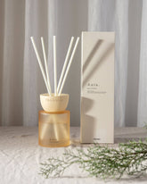 Aura clay reed diffuser with amber glass, cream ceramic bowl, and six white reeds for sea salt freshness