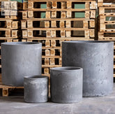 Gray onyx dusk cylinder planter made of pigmented concrete with a rough textured surface and 30cm height for plants