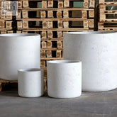 White mist cylinder planter made of white concrete with a rustic finish and a 77cm planting opening