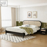 Black-framed barbara queen size bed with woven cane headboard and nightstand dressed in white linens and olive throw