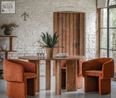 Rust-colored velvet armchairs with rounded modern design paired with bardo round dining table for stylish round dining table setup