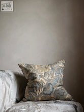 A square cushion in barnabus pattern featuring vintage liberty cotton with muted blue gray and beige tones