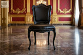 Black leather baroque dining chair with ornate gold trim and curved legs perfect for elegant dining setups