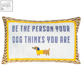 White embroidered needlepoint cushion with yellow border and brown trim featuring dog thinks phrase and dachshund design