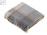 A soft beige and grey block windowpane lambswool throw with fringed edges in merino lambswool material