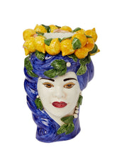 A ceramic bust statue shaped like a woman’s face with blue hair and a crown of yellow lemons and green leaves called blu lemon