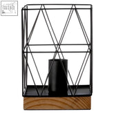 Black metal table lamp with a geometric wire candle holder and wooden base for modern decor