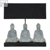 Black rectangular buddha lamp with three grey stone buddha statues seated in a row beneath the shade