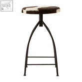 Black metal bar stool with round brown and white cowhide seat perfect for a stylish cowhide bar setup