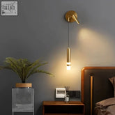 Bold gold wall lamp with a sleek gold finish and cylindrical reading light hanging from a wall-mounted fixture