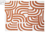 A bosie ozella terracotta throw featuring a rectangular rug with a bold two-tone pattern of curved orange lines on white
