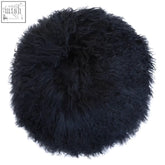 A plush round cushion in black made from bosie real mongolian fur with dense curly texture perfect for cozy spaces