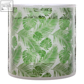 Botanical large hurricane candle holder with white base and rim featuring green tropical leaf pattern on glass large hurricane candle