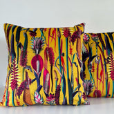 Vibrant botanical mustard velvet throw cushion with bold tropical print in reds pinks and deep greens on plush fabric