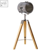 Industrial-style bray table lamp with chrome spotlight head and wooden tripod base for stylish lighting
