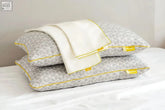 Gray geometric brightr luna pillow with yellow piping and matching copper pillow protectors tags visible