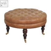 Brown buffalo leather round ottoman with tan tufted top solid mango wood legs and brass castor wheels for storage bench