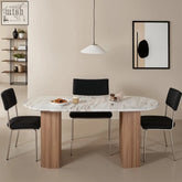 Marble-top dining table with natural marble surface and fluted mango wood legs paired with black upholstered chairs